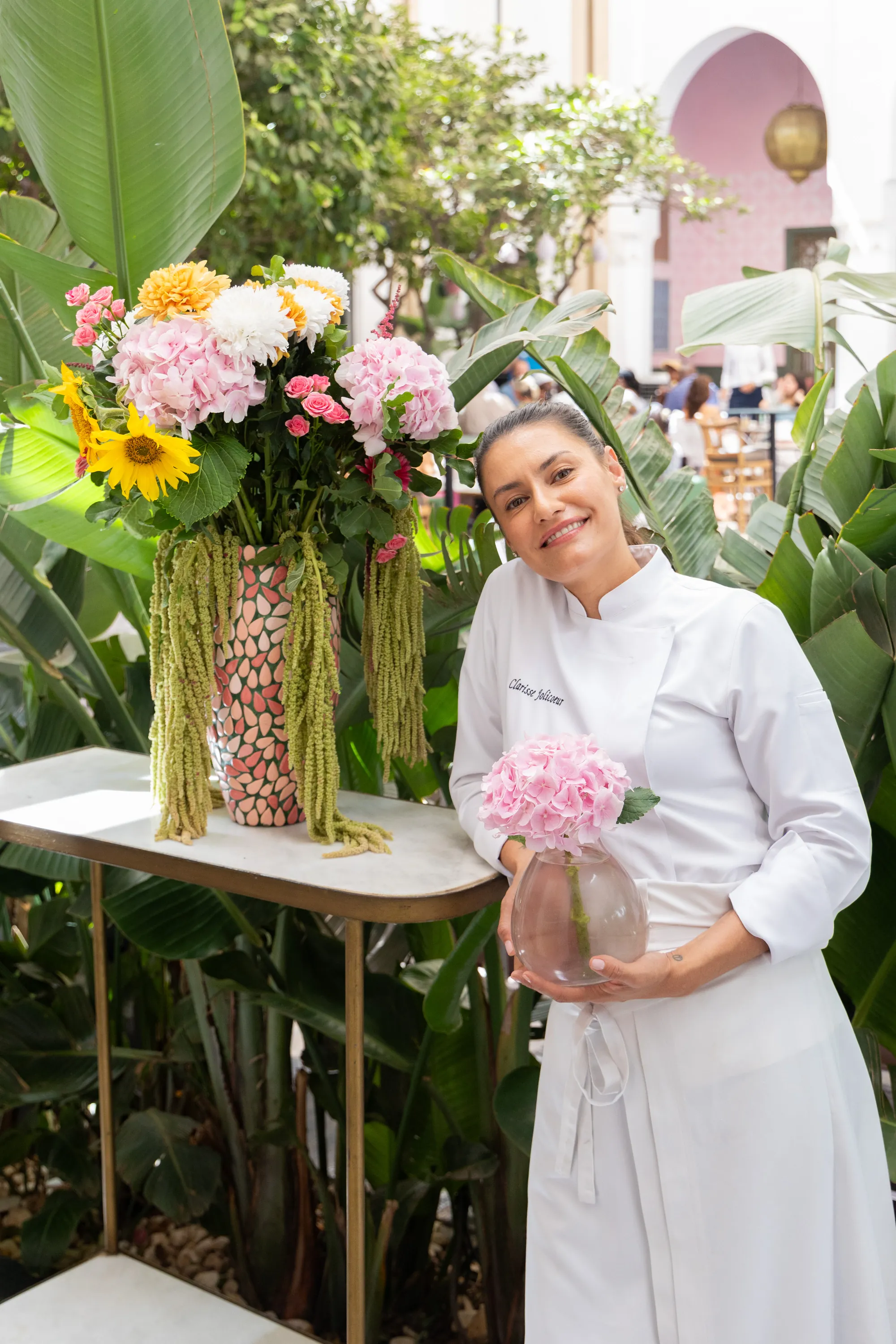 Clarisse Jolicoeur entourée de fleurs dans le jardin